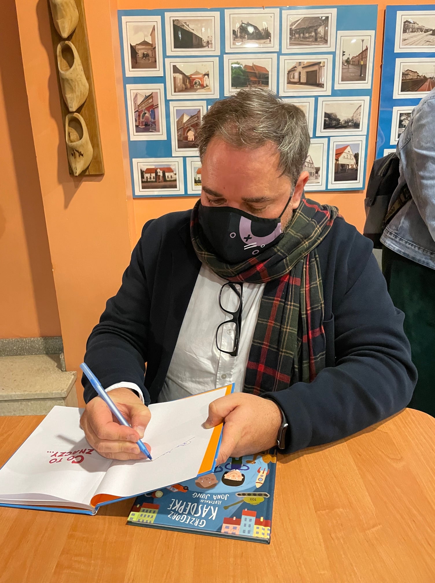 Pisarz Grzegorz Kasdepke podczas wpisywania dedykacji do jednej ze swoich książek.