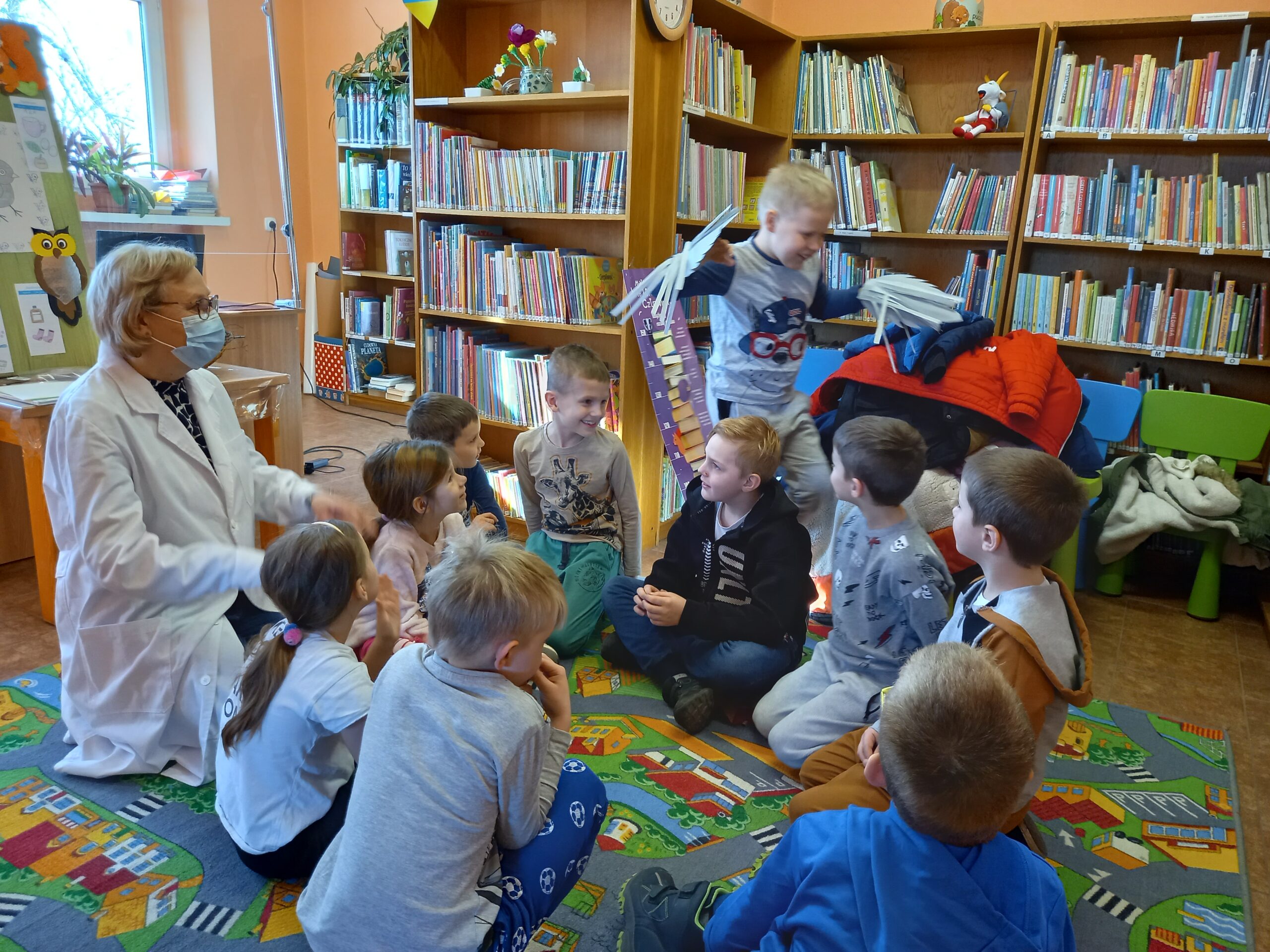 Bibliotekarka z grupą dzieci w bibliotece w Gułtowach.
