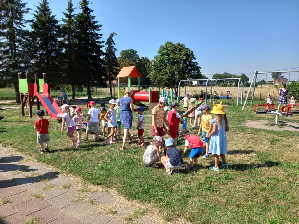 Dzieci bawią się na placu zabaw w słoneczny dzień.