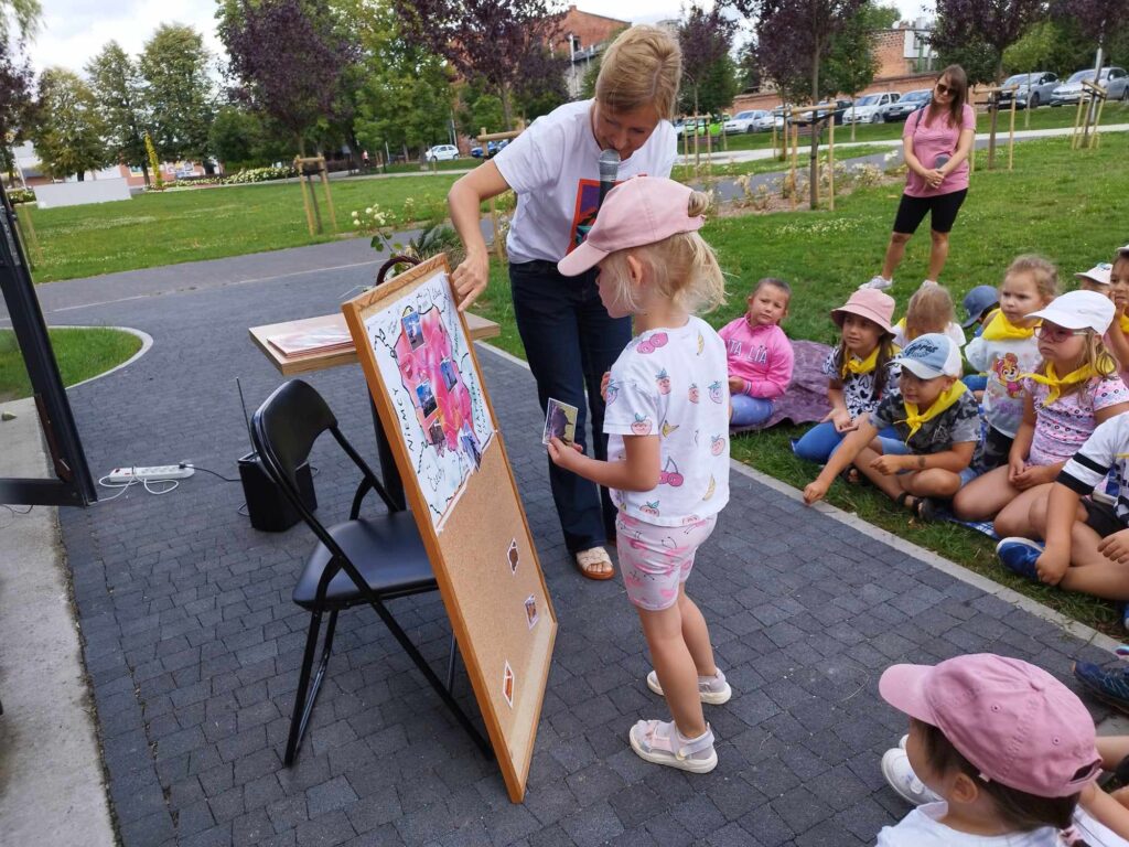 Przedszkolaki zgromadzone w parku przy Stacji Książki uczestniczą w Literackim Czwartku.