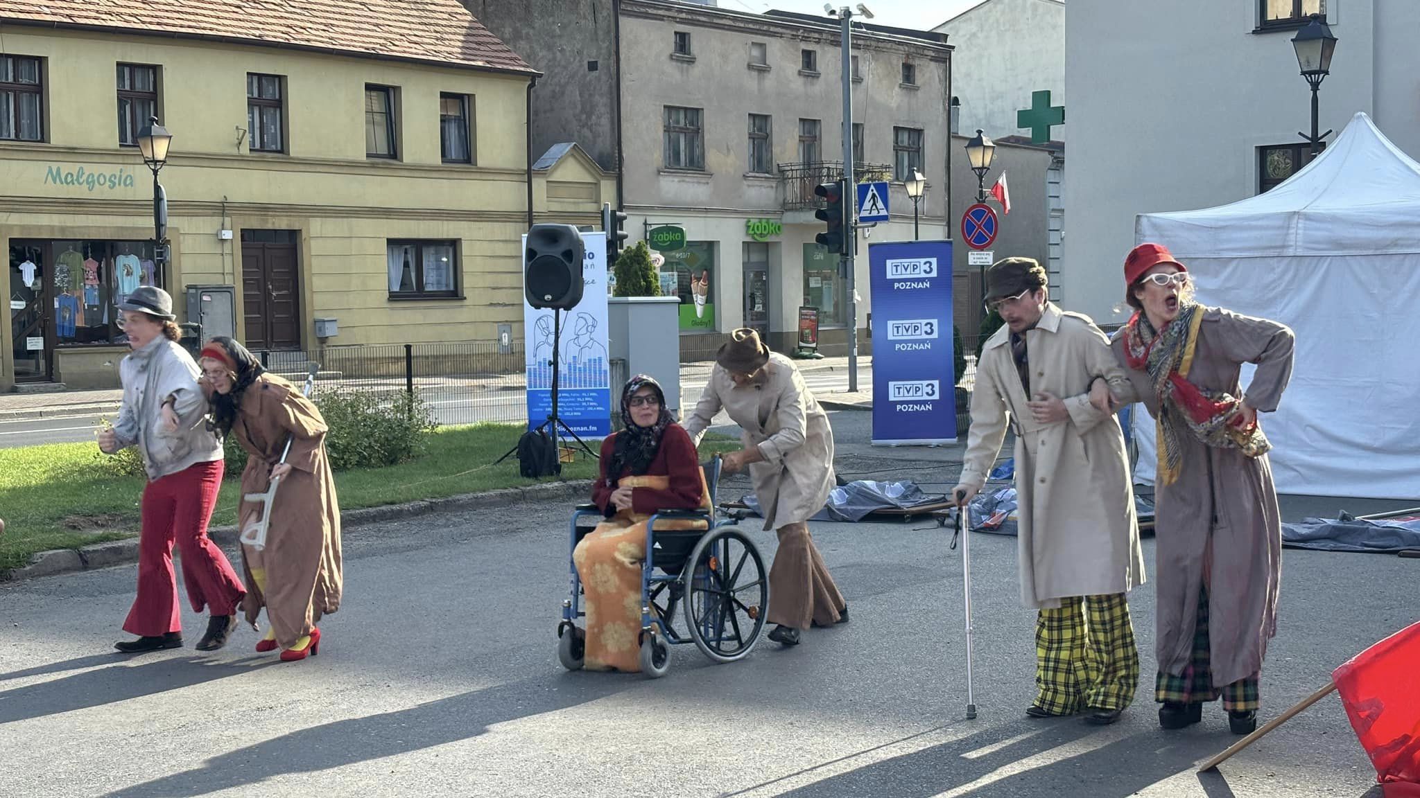 Zdęcie przedstawia aktorów w ubraniach z czasów PRL, występujących na kostrzyńskim Rynku.