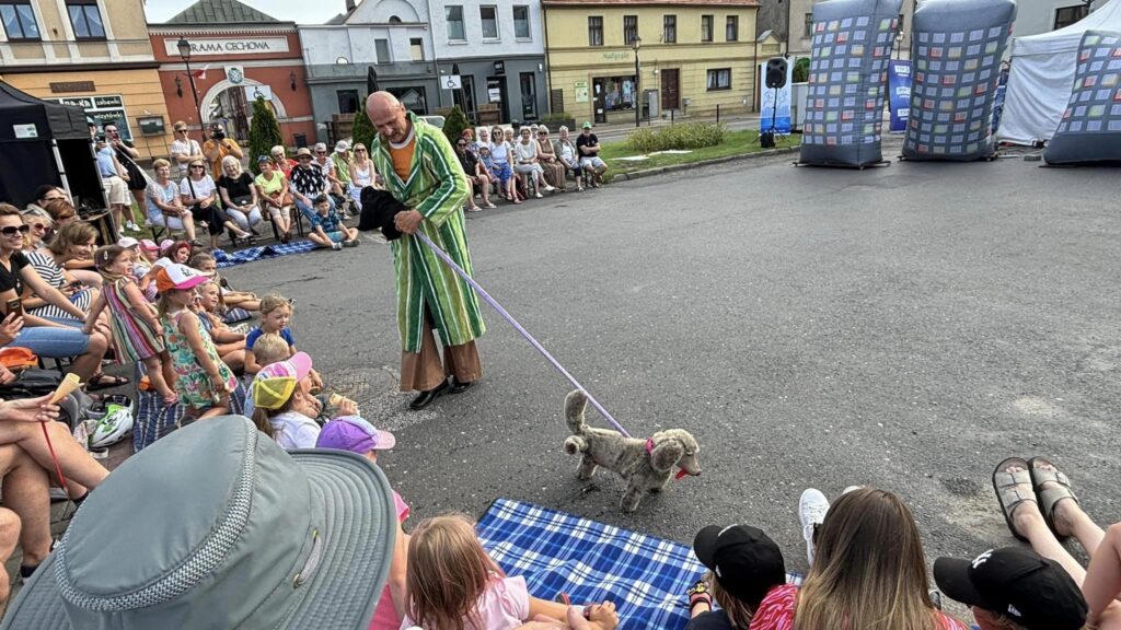 Zdęcie przedstawia aktorów w ubraniach z czasów PRL, występujących na kostrzyńskim Rynku.